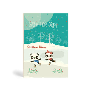 Light blue A6 Eco-Friendly, recyclable, biodegradable, green, tree-free Winter joy, Christmas Wishes – two Pandas Skating on Lake greeting card, with snowflakes and trees in the background.